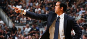 Coach Spoelstra communicating with players from the sideline during a game.